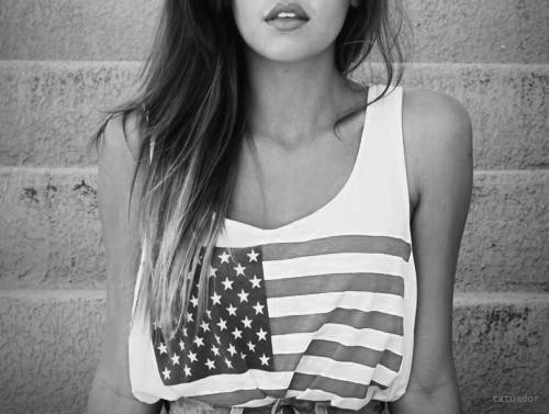Black and white photo of a woman's in a strapless blouse with the flag of the United States