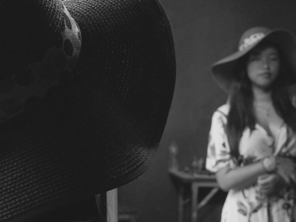Black and white mirror image of a woman of Asian beauty wearing a hat
