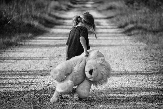 girl carrying big teddy bear