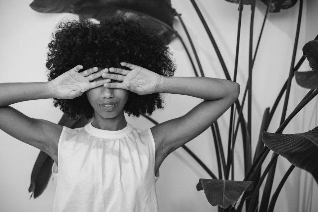 A girl covering her eyes because of Anxiety When Speaking a Foreign Language.