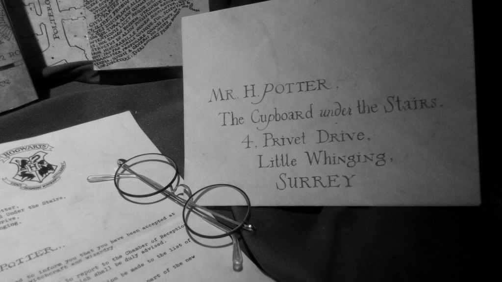 Kadr z filmu o Harrym Potterze. List do Harrego i okulary.