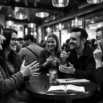 Black-and-white image of friends having a lively conversation in a busy café, illustrating the challenge of understanding fast native speech.